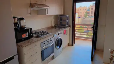 a kitchen with a stove and a washing machine at Hivernage Cosy in Marrakech