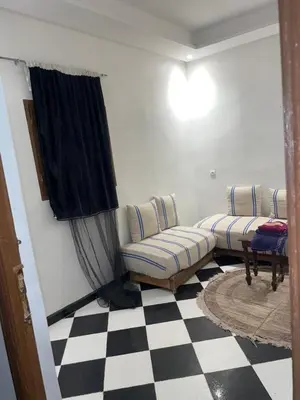 a living room with a couch and a checkered floor at Mini Studio in Marrakech
