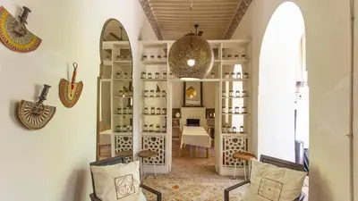a room with two chairs and a shelf with bottles at Dar Z5 3 bedrooms in Marrakech