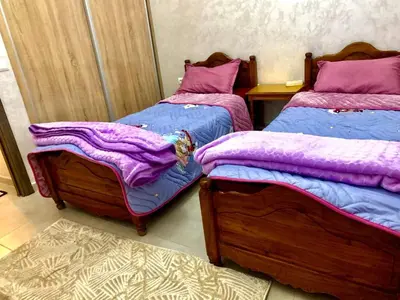 two beds in a room with purple blankets on them at Appartement Marrakech in Marrakech