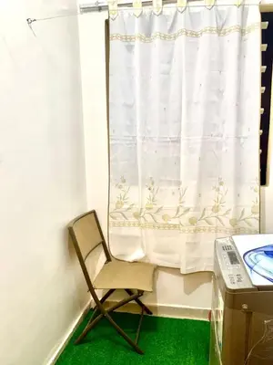 a chair in front of a window with a curtain at Appartement Marrakech in Marrakech