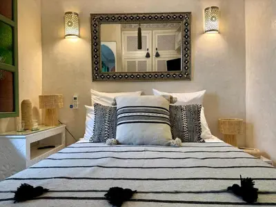a bedroom with a large bed with a mirror at Riad Dar Najwa in Marrakech