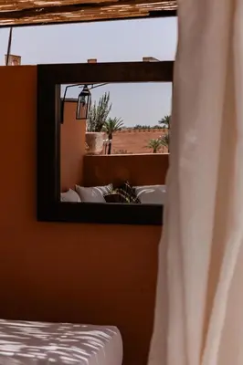 a mirror in a room with a bed and a window at Riad de charme avec piscine rooftop in Marrakech