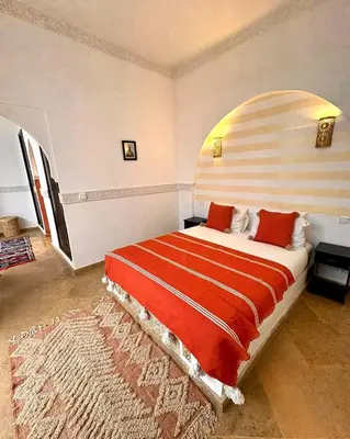 a bedroom with a large bed in a room at Riad de charme avec piscine rooftop in Marrakech