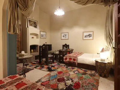 a bedroom with a bed and a living room at Riad Villa Elgada in Marrakech