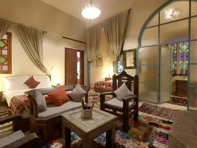 a living room with a bed and a couch at Riad Villa Elgada in Marrakech