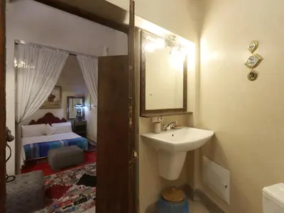 a bathroom with a sink and a mirror and a bedroom at Riad Villa Elgada in Marrakech