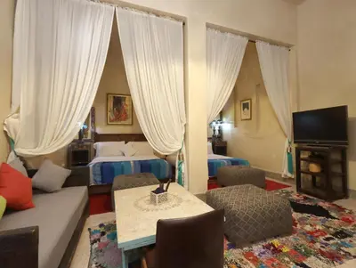 a hotel room with two beds and a living room at Riad Villa Elgada in Marrakech