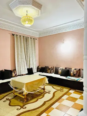 a living room with a table and a couch at Aéroport, Appartement in Marrakech