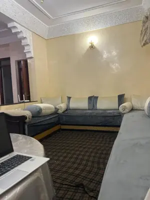 a room with a couch and a laptop on a table at Aéroport, Appartement in Marrakech