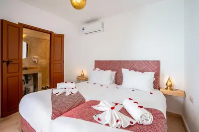a bedroom with a white bed with red and white bows at Riad Ilyan & Spa in Marrakech