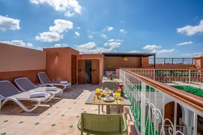 a patio with chairs and a table on a balcony at Riad Ilyan & Spa in Marrakech