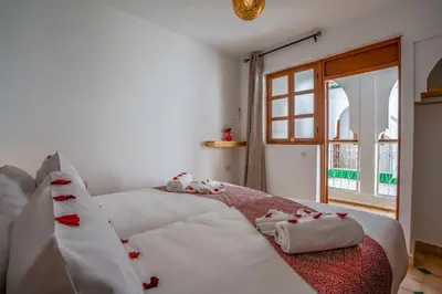 a bedroom with a bed with white sheets and a window at Riad Ilyan & Spa in Marrakech