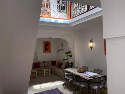 a living room with a table and a couch at L'Alchimiste - Riad Entier à 10 minutes Jemaa El Fna in Marrakech