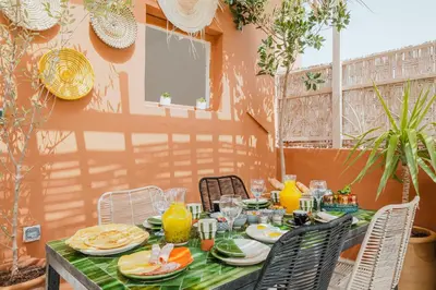 a table with plates of food and orange juice at Maison 3 chambre avec bassin chauffée centre ville Gueliz in Marrakech