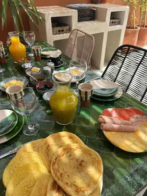 a table with bread and other foods on it at Maison 3 chambre avec bassin chauffée centre ville Gueliz in Marrakech