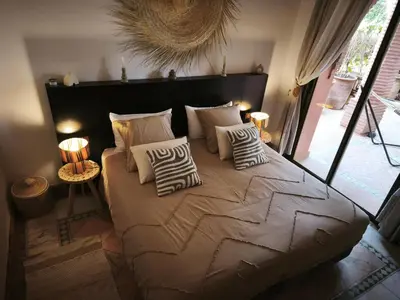 a bedroom with a large bed with pillows on it at Nohaya - Palmeraie 2 Marrakech Un cadre verdoyant et reposant in Marrakech