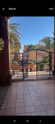 a gate in a courtyard with a palm tree at Steps from Airport only 5 minutes ,Ideal for Travelers in Marrakech