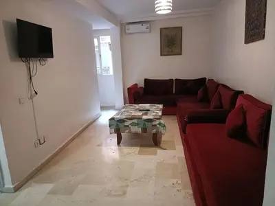 a living room with a red couch and a table at family apartment 06 in Marrakech