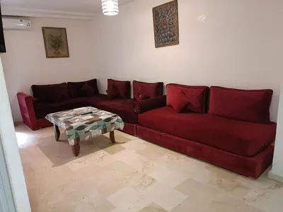 a living room with a red couch and a table at family apartment 06 in Marrakech