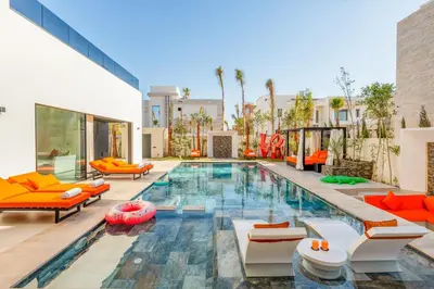 an indoor pool with orange and white furniture in a house at Luxury Villa Heated Pool, Cinema & Game Room in Marrakech