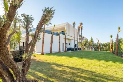 a building with palm trees in front of it at Luxury Villa Heated Pool, Cinema & Game Room in Marrakech