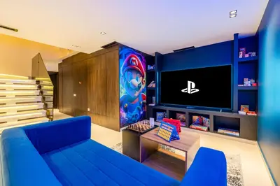 a living room with a blue couch and a tv at Luxury Villa Heated Pool, Cinema & Game Room in Marrakech