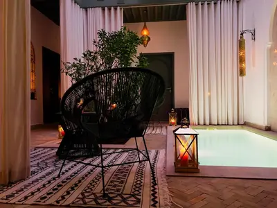 a black chair sitting in front of a bath tub at Riad Kaya in Marrakech