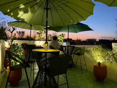 a person sitting at a table under an umbrella at Riad Kaya in Marrakech