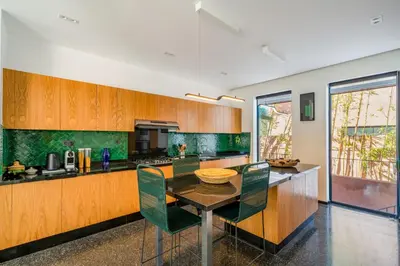 a kitchen with a table and some green walls at Villa Nomade - 4 BR BA - Piscine - Parking - Ourika in Sraghna