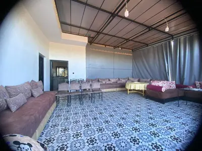 a living room with couches and a table and chairs at Waha hassan 2 in Marrakech
