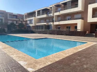 a swimming pool in front of a building at Cozy apartment with pool Bd Mohamed 6 in Marrakech