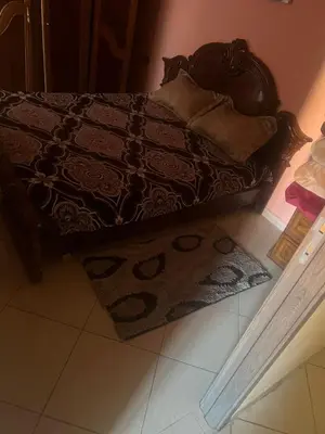 a bedroom with a bed with a rug on the floor at Appartement a côté Aéroport Menara marrakech in Marrakech