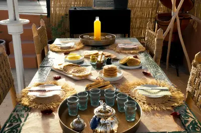 a table with food and a candle on it at Savor Home Authentic Entire Riad with Medina View & Terrace in Marrakech