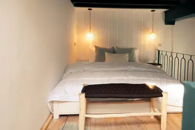 a bedroom with a large white bed with a bench at Savor Home Authentic Entire Riad with Medina View & Terrace in Marrakech