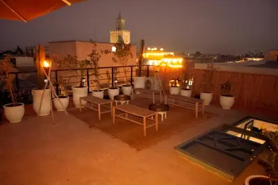 a balcony with benches and potted plants at night at Savor Home Authentic Entire Riad with Medina View & Terrace in Marrakech
