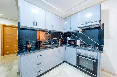 a kitchen with white cabinets and black counter tops at Comfort and Serenity in the Center of Marrakech in Marrakech