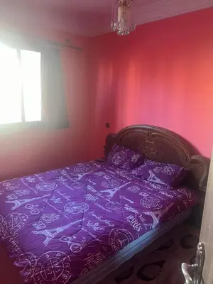 a bedroom with a bed with purple sheets and a window at Aéroport Menara marrakech in Marrakech