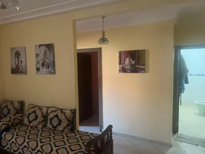 a living room with a couch and pictures on the wall at Aéroport Menara marrakech in Marrakech
