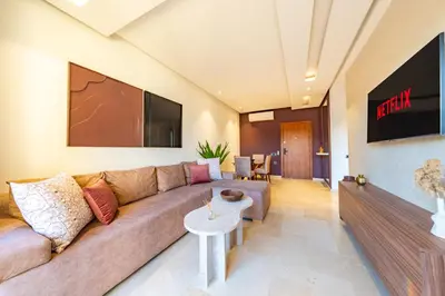 a living room with a couch and a flat screen tv at 2-Bedroom Residence Jubeae - Pool & Golf Nearby in Marrakech