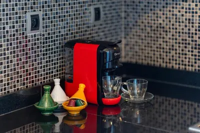 a coffee maker sitting on top of a counter with cups at 2-Bedroom Residence Jubeae - Pool & Golf Nearby in Marrakech