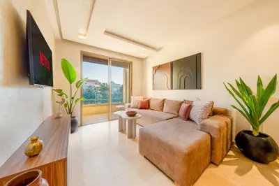 a living room with a couch and a tv at 2-Bedroom Residence Jubeae - Pool & Golf Nearby in Marrakech