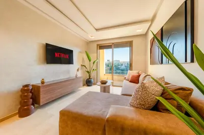 a living room with a couch and a table at 2-Bedroom Residence Jubeae - Pool & Golf Nearby in Marrakech