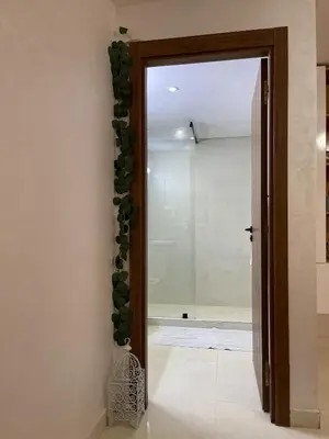 a hallway with a door with a bunch of green plants at Home Star Luxury Apartment Marrakech in Marrakech