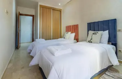 a bedroom with two beds with white sheets at Marrakech Haven Appartement Familial Wifi HD IPTV Netflix in Marrakech