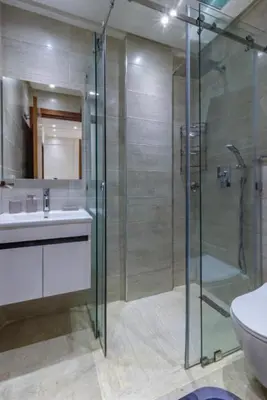 a bathroom with a glass shower and a sink at Marrakech Haven Appartement Familial Wifi HD IPTV Netflix in Marrakech