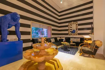 a living room with a blue and white striped wall at Oasis - 7 min from Majorelle - Medina and Nightlife with AC and Pool in Marrakech