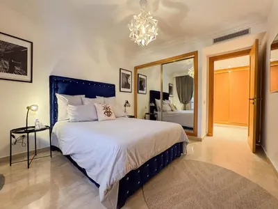 a bedroom with a large bed and a chandelier at Oasis - 7 min from Majorelle - Medina and Nightlife with AC and Pool in Marrakech