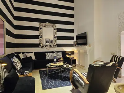 a living room with a black and white striped wall at Oasis - 7 min from Majorelle - Medina and Nightlife with AC and Pool in Marrakech