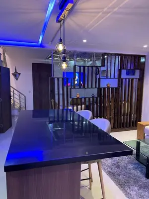 a dining room with a black table and chairs at Duplex Luxury Appartement in Marrakech